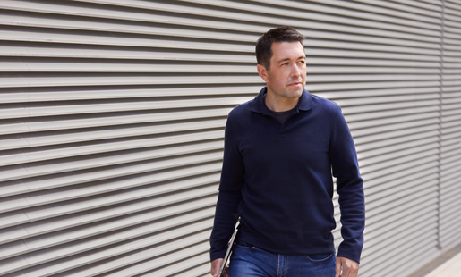 Rob marchant dehors en tenant son portable.